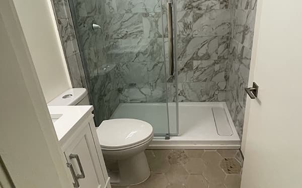 Renovated bathroom with a marble-look walk-in shower